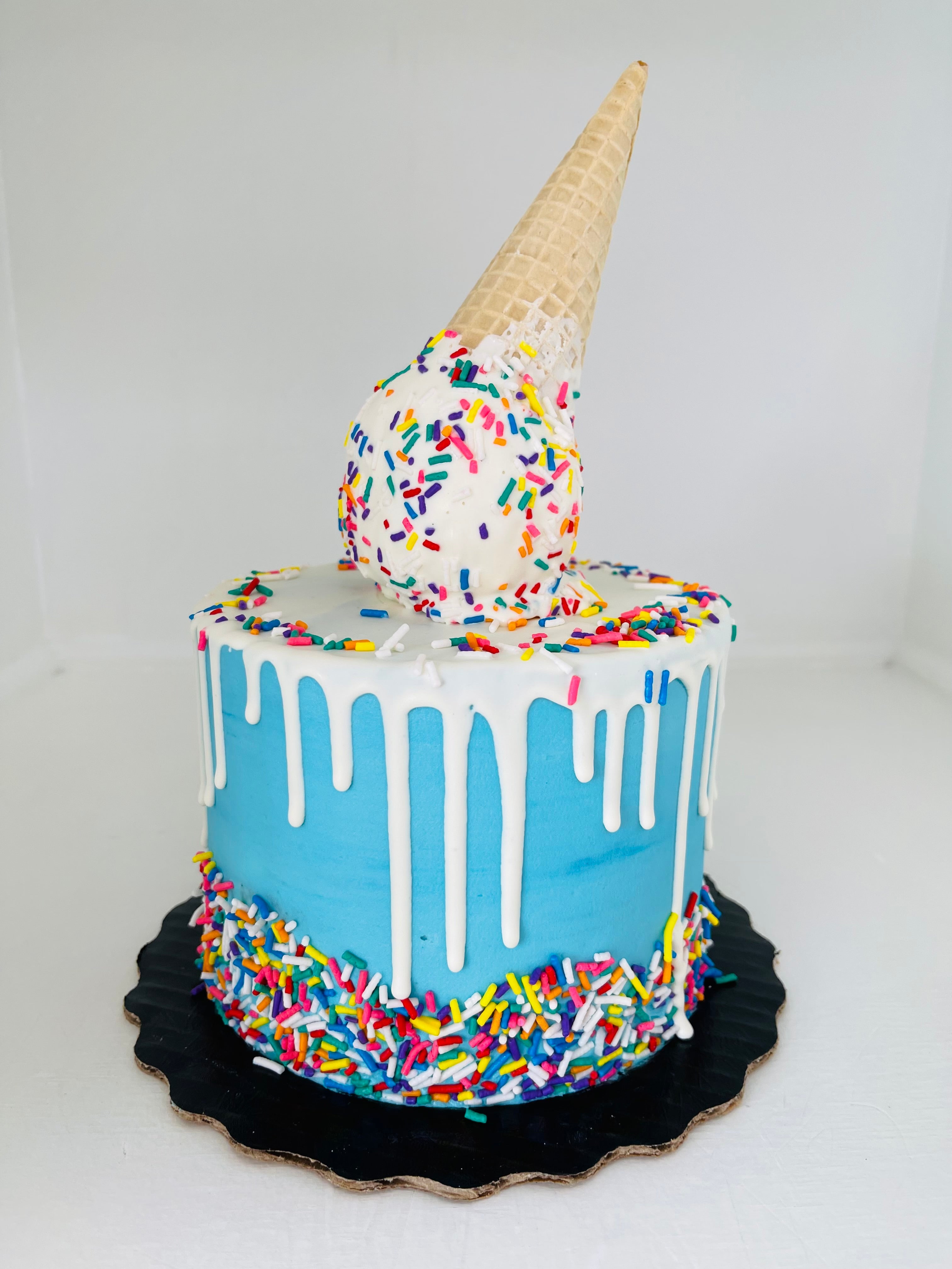 Cake with ice cream cone and colorful sprinkles on a white background