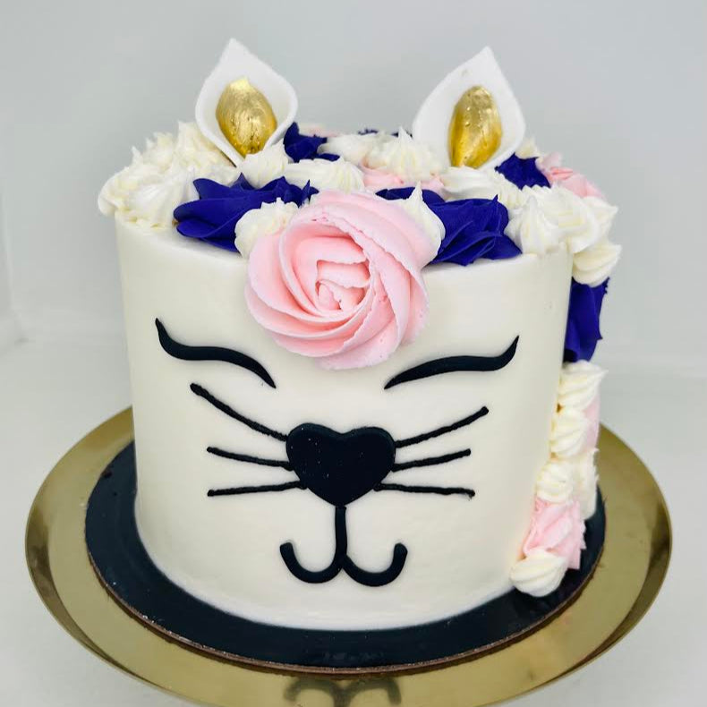 Cat-themed cake with floral decorations on a white background