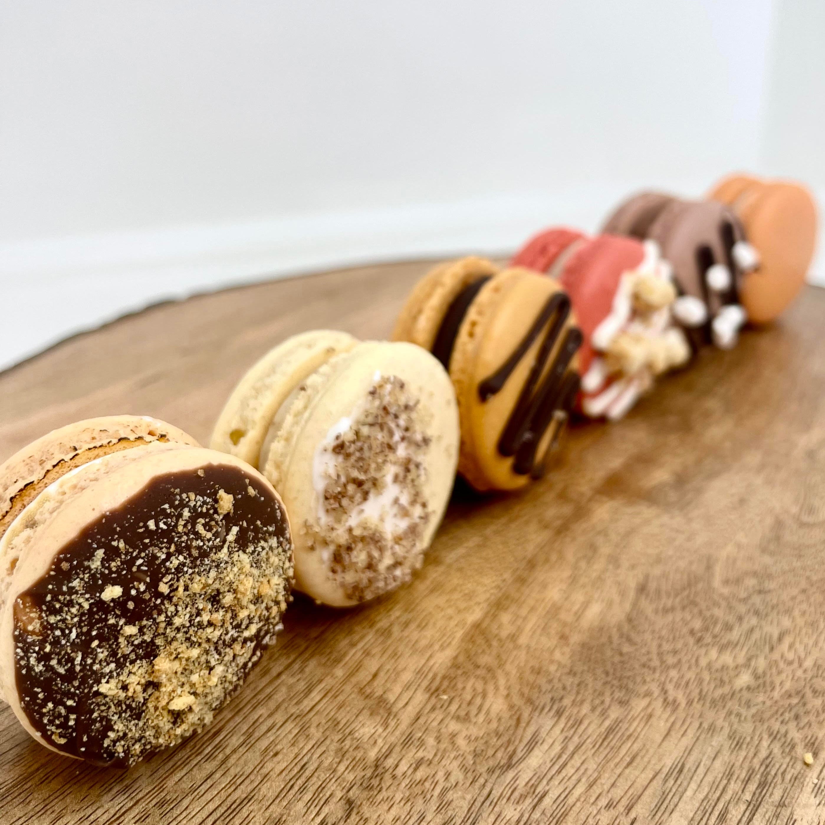 Row of fall themed macarons with various toppings on a wooden board