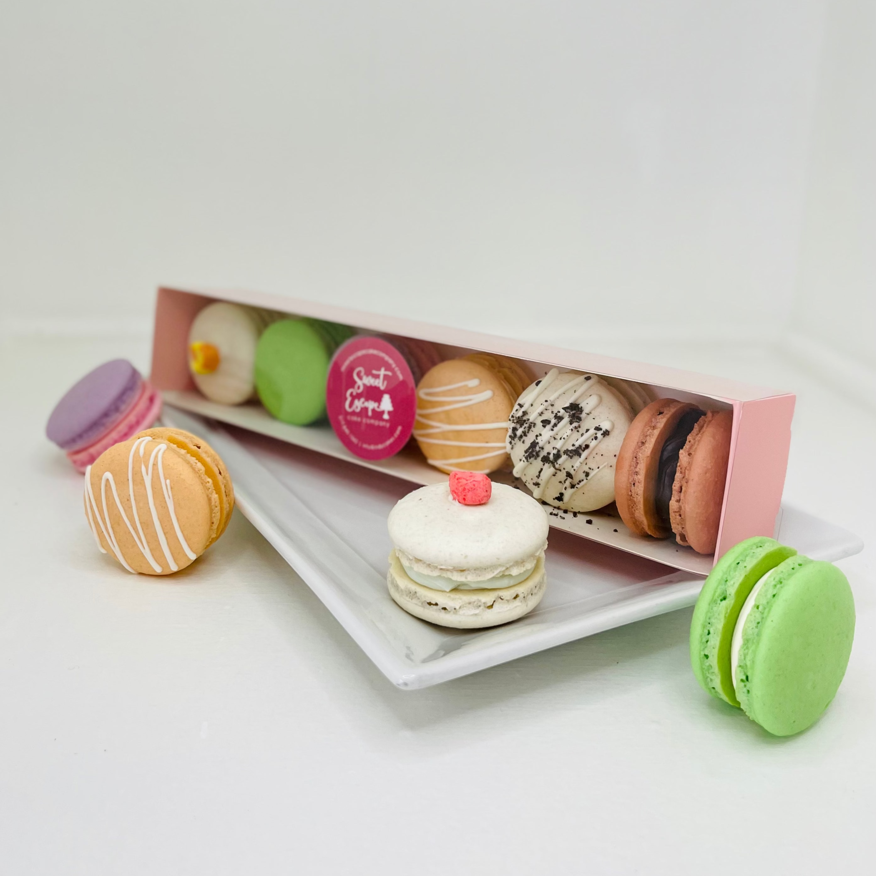 Colorful macaron cookies in a box on a white surface
