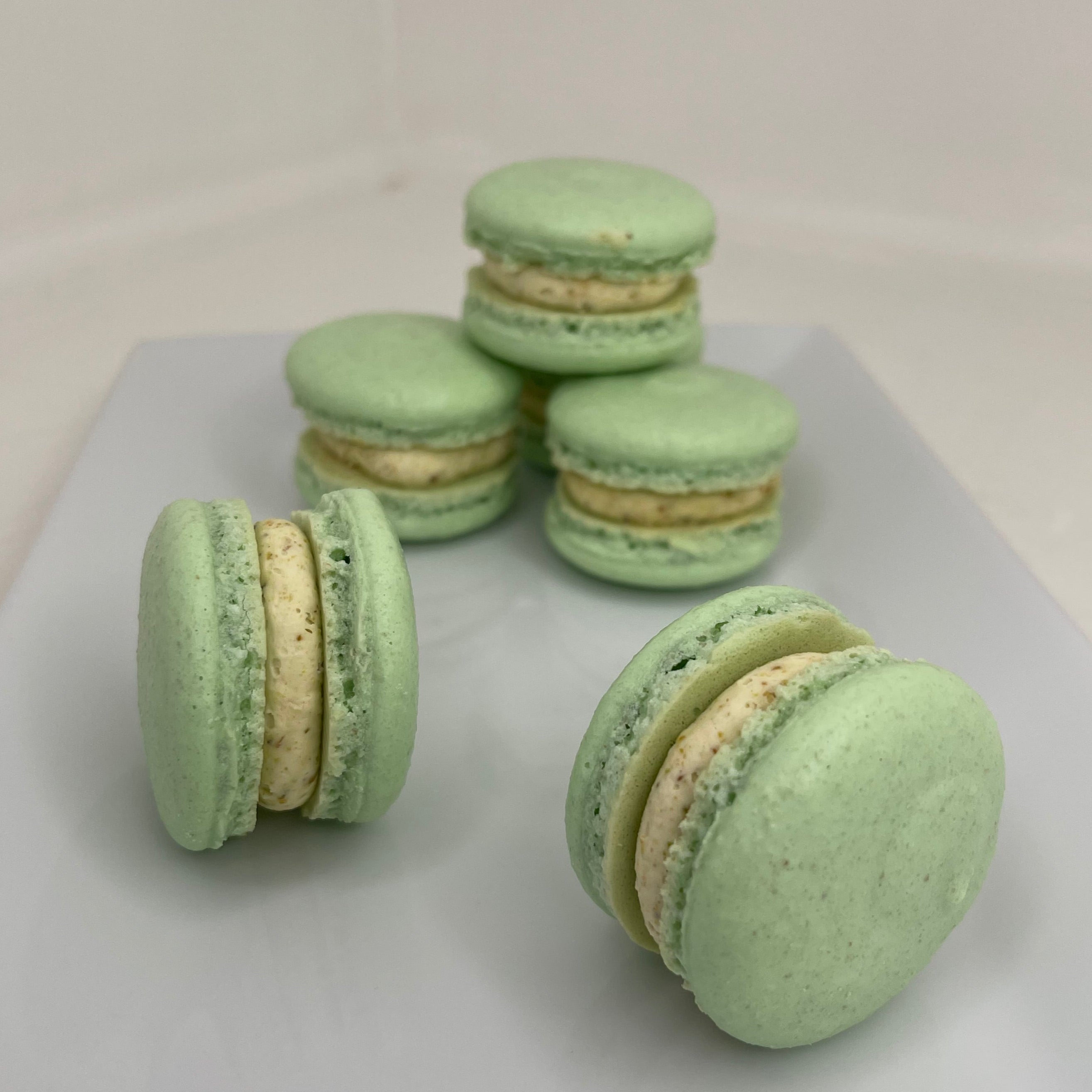 Green macarons on a white surface