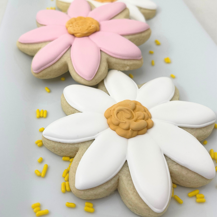 Decorative cookies shaped like flowers on a white surface.