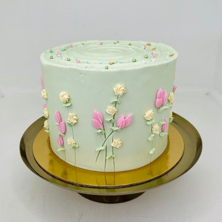 Light green cake with floral decorations on a white background
