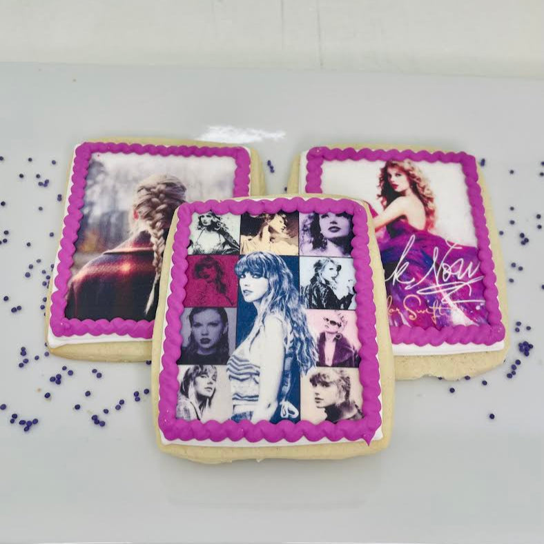 Decorative Taylor Swift inspired cookies with images and text on a white surface