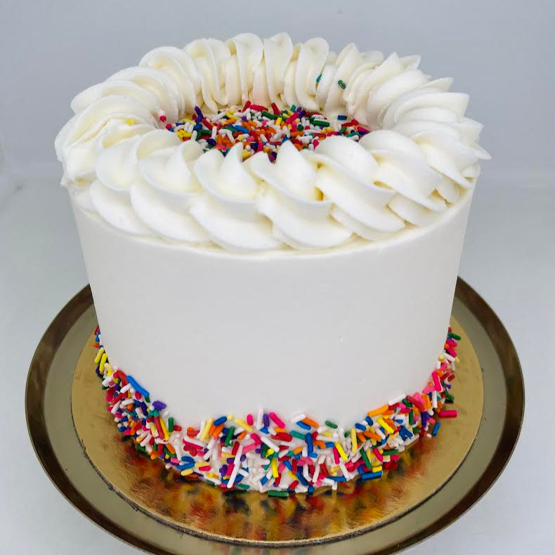White cake with colorful sprinkles on a white background