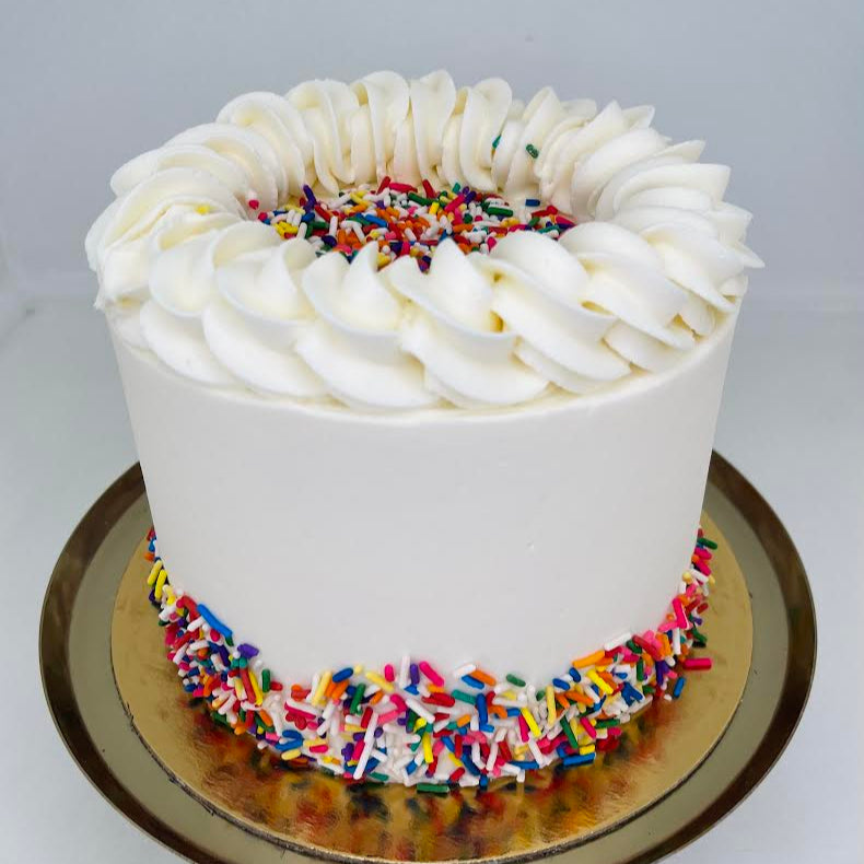 White cake with colorful sprinkles on a white background