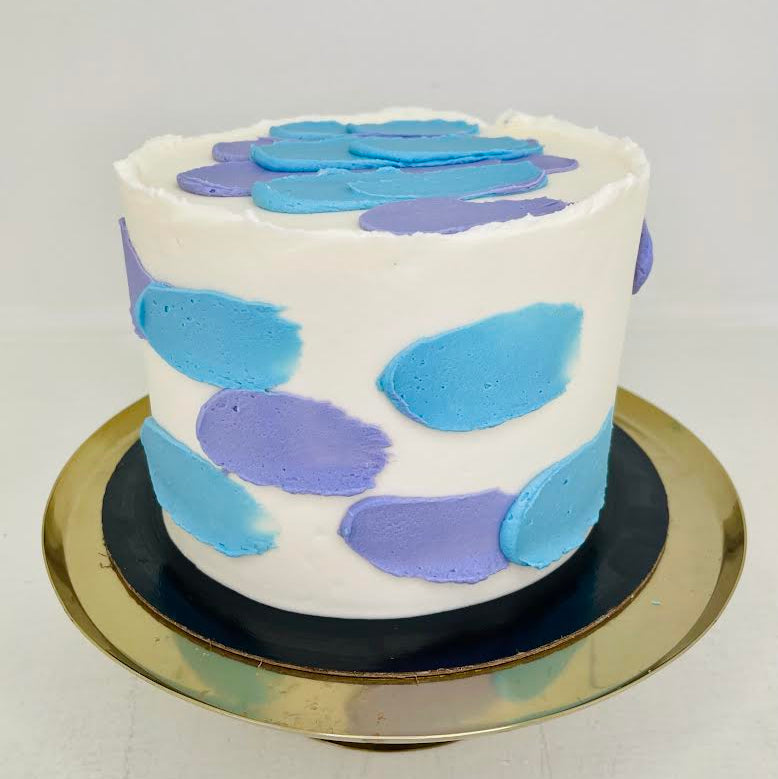 White cake with blue and purple brushed design on a white background